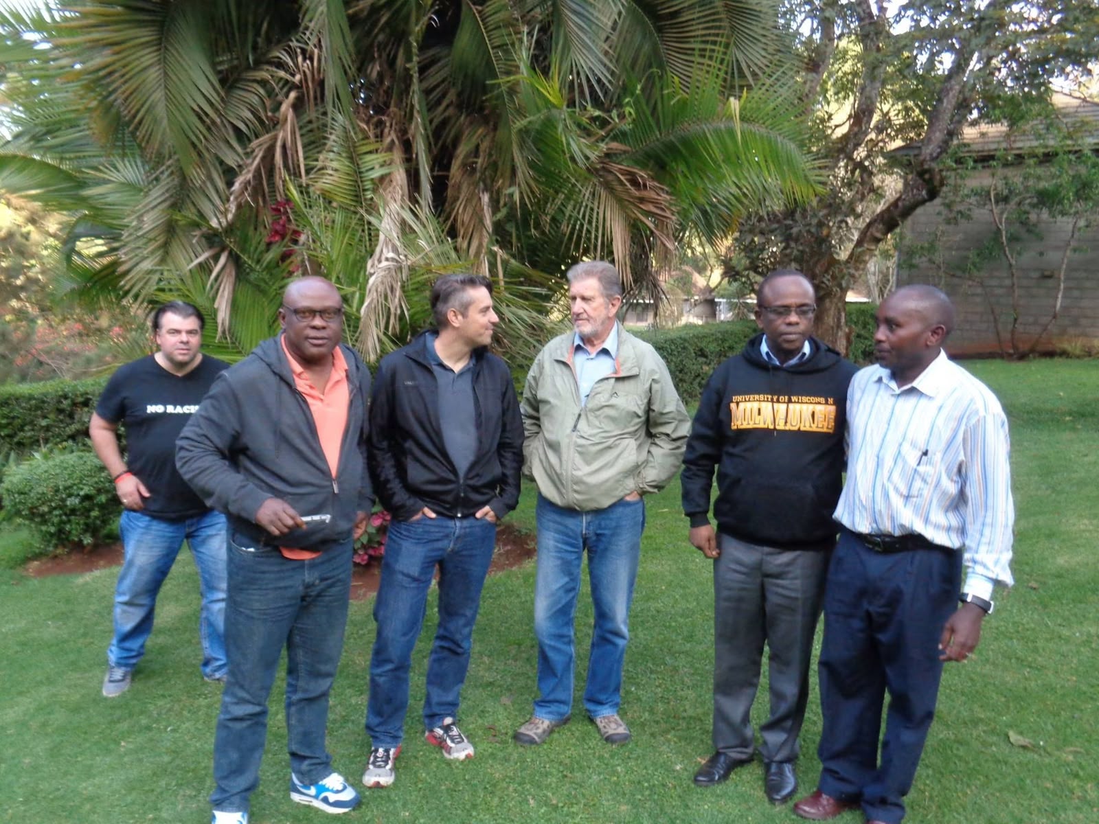 Six founding members stand together on the lawn at Thayu resort, with palm trees behind them, during the September 2016 SPEC founding retreat.