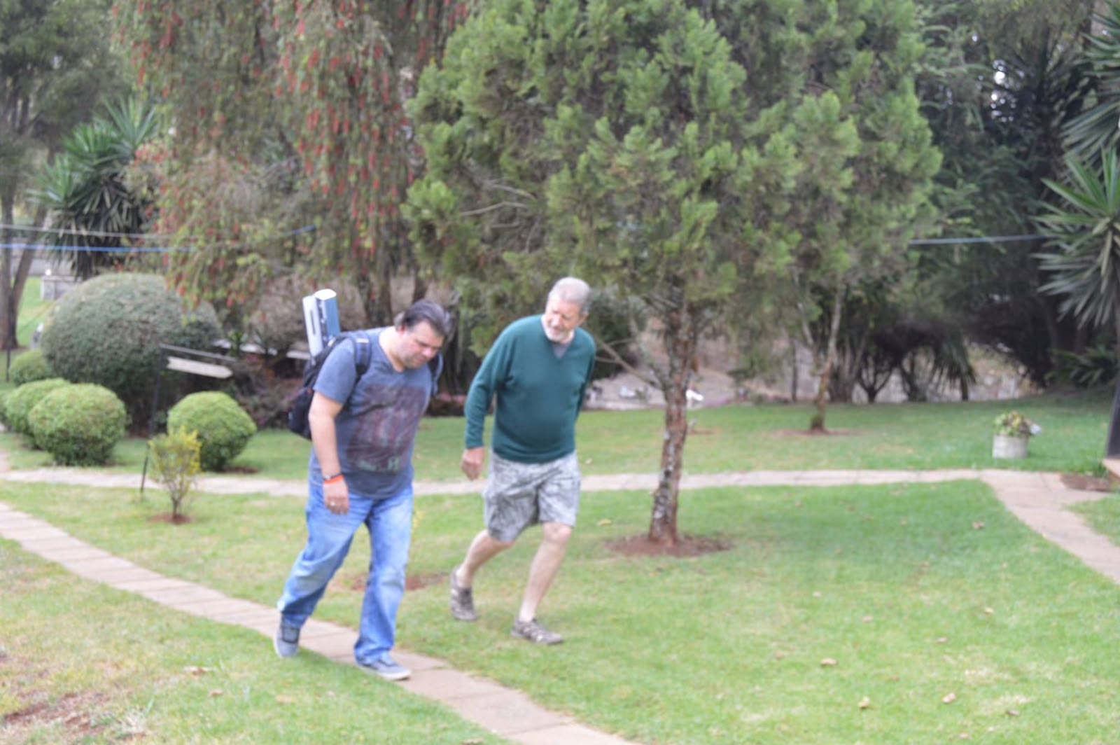 Two founding members walk along a garden path at Thayu resort, one carrying a backpack, during the September 2016 SPEC retreat.