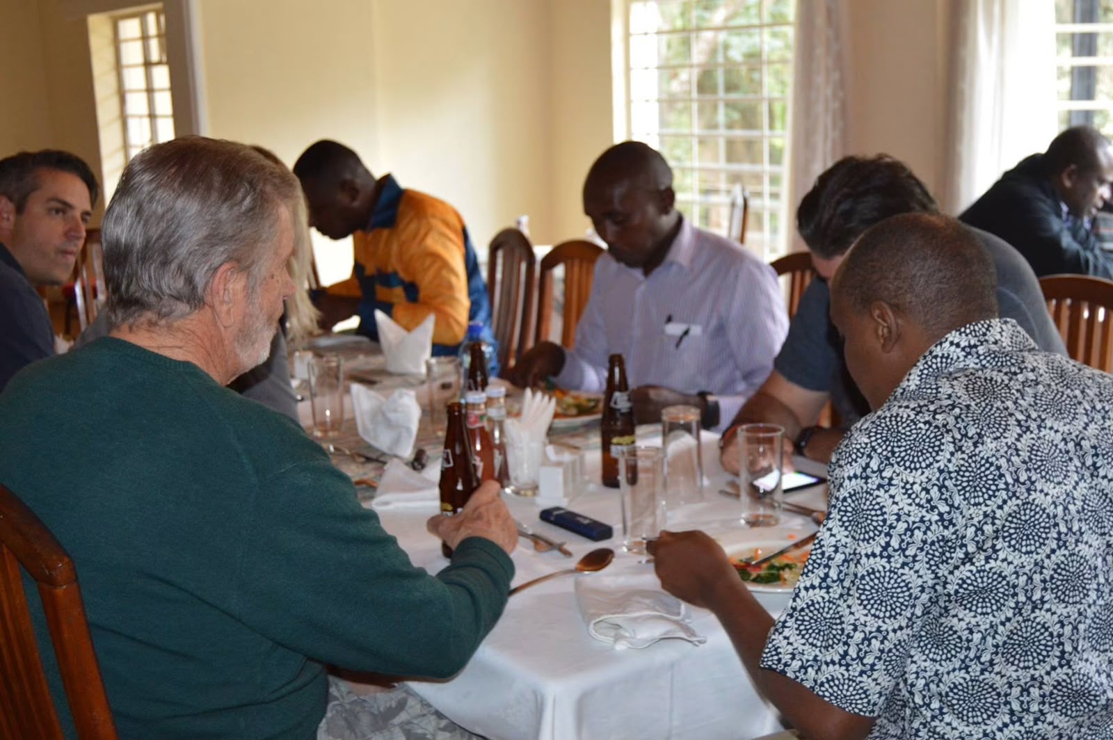 Founders gather around a dining table indoors at Thayu resort, eating and drinking together during the September 2016 SPEC founding retreat.